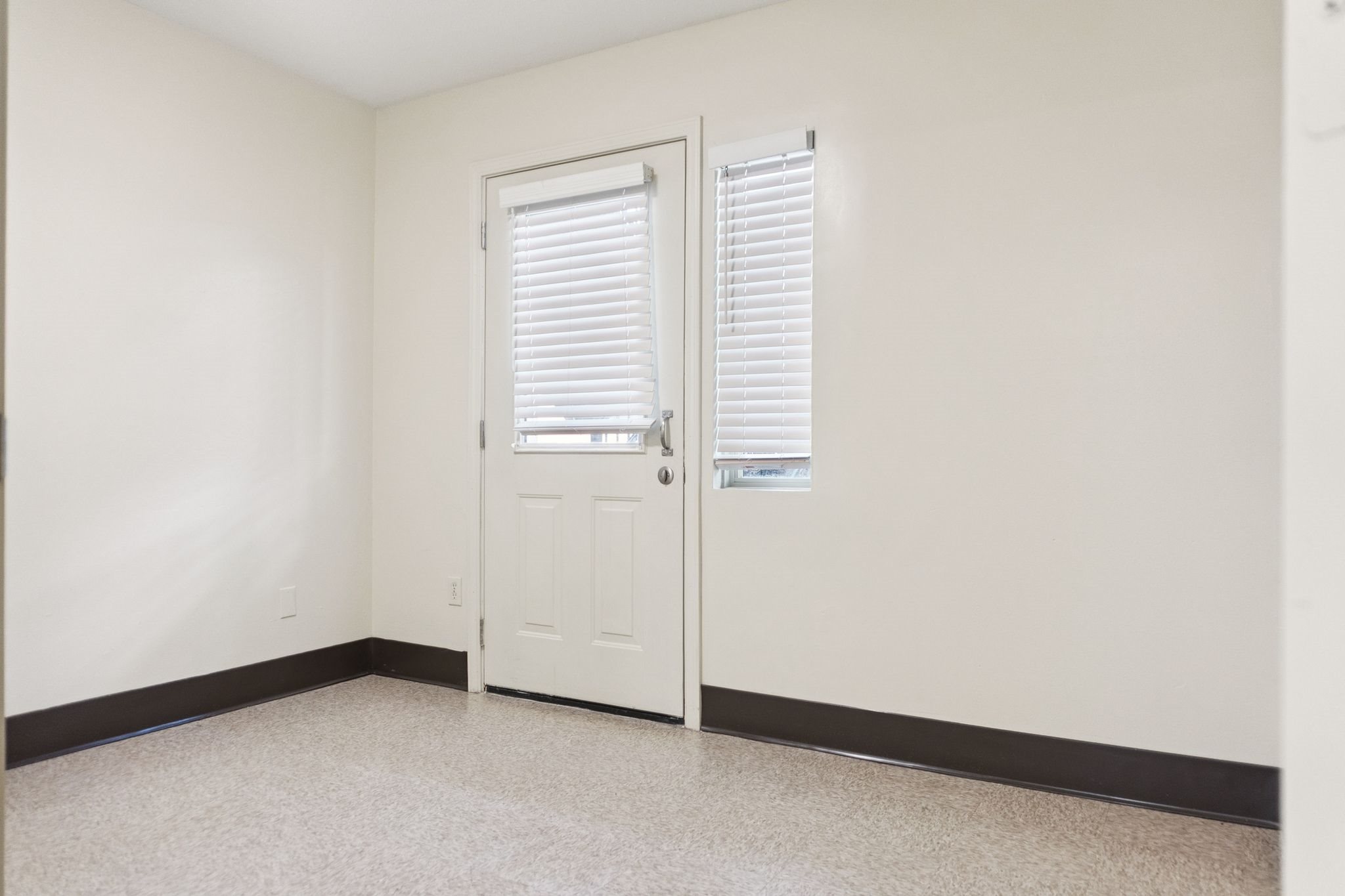 A white door with a window above it in a room.